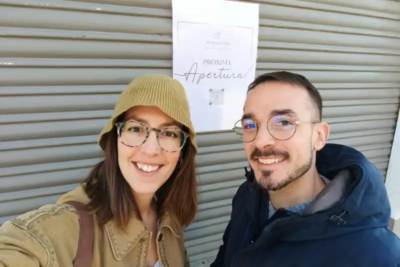 Andrea y Mila, equipo del obrador artesanal Andrea Forte, sonriendo frente a su local de panadería y pastelería artesanal en Valencia.