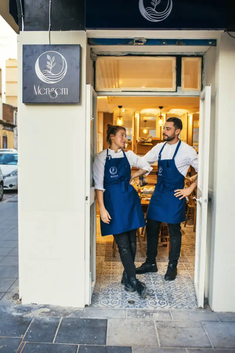 Miembros del equipo de Mengem Bistro en la entrada de su local en Cabanyal, Valencia, colaboradores de Andrea Forte Panadería-Pastelería y defensores de la cocina sostenible y el producto local.